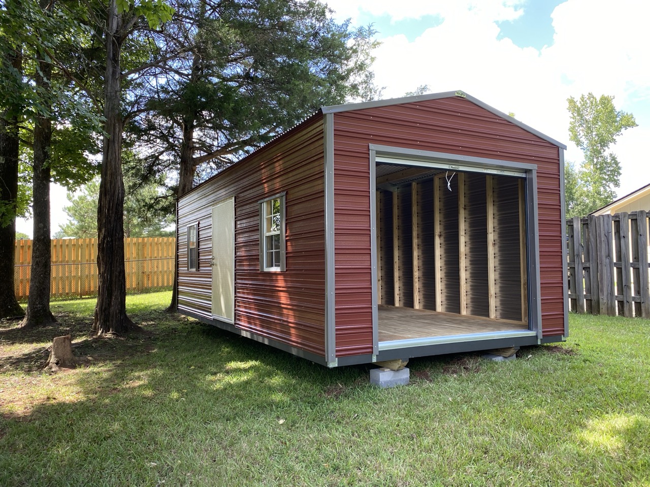 Barn loft maroon aluminum shed with roll-up door open