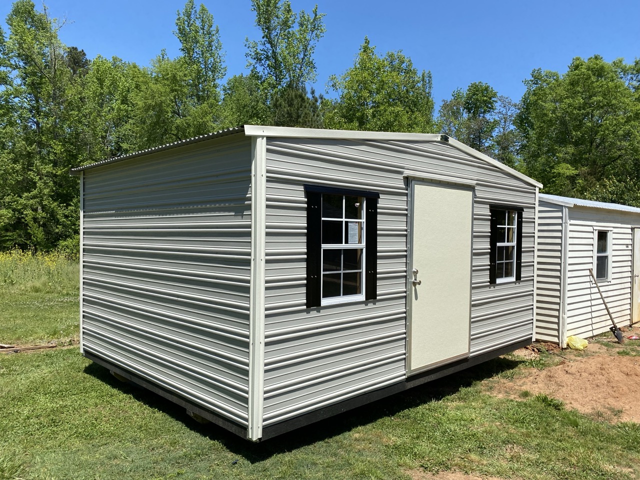 Gray aluminum shed with black shutters