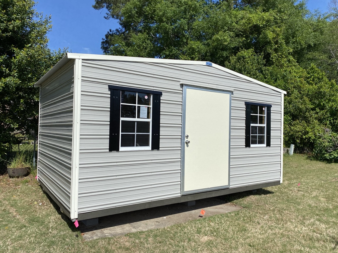 Gray aluminum shed with black shutters