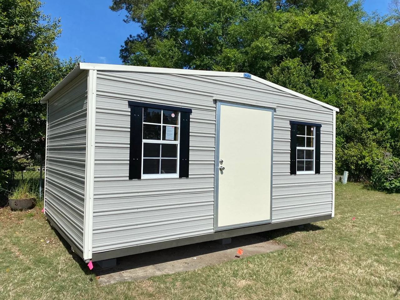 Gray aluminum shed with black shutters