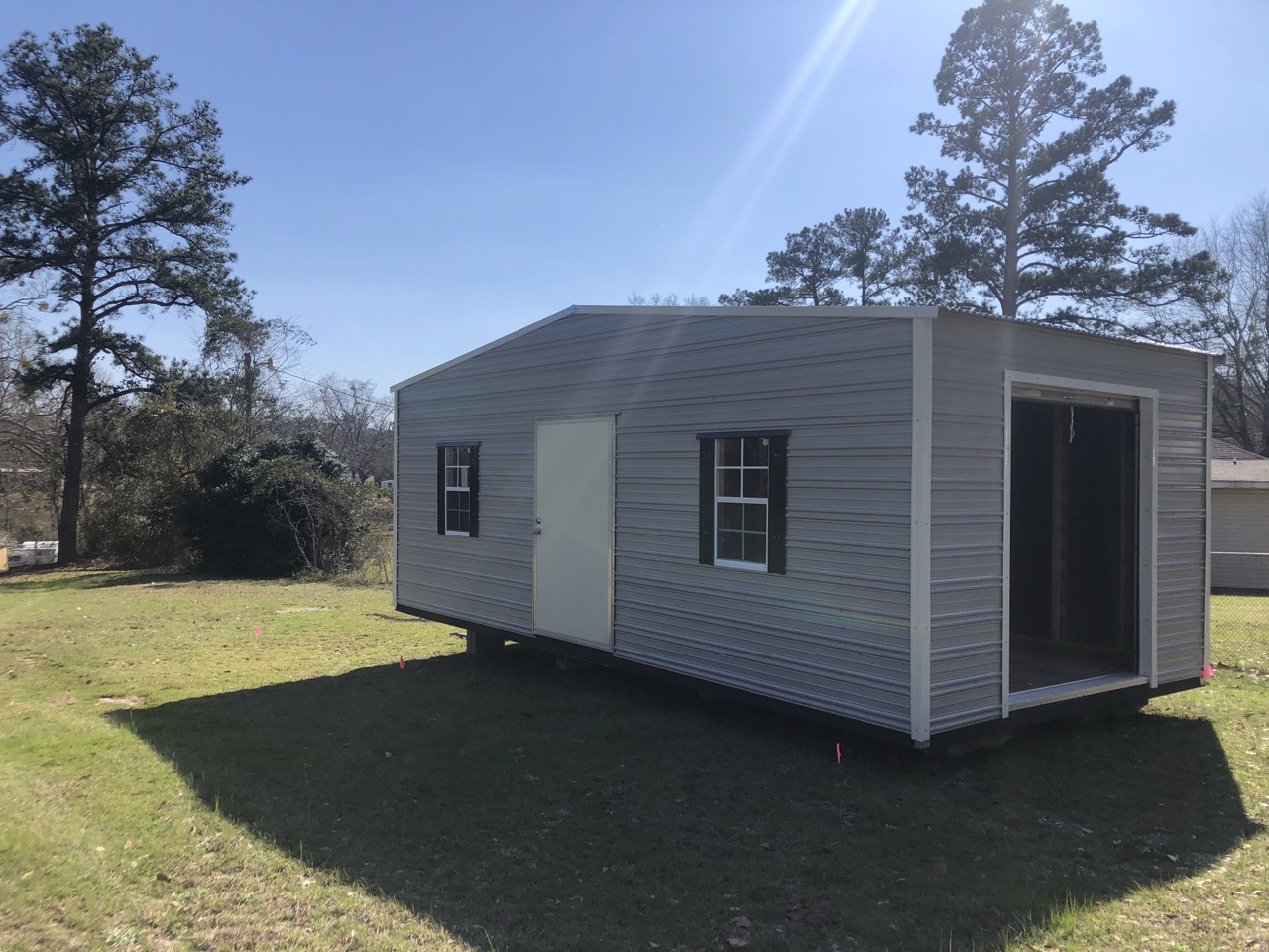 Gray aluminum shed with roll-up door open