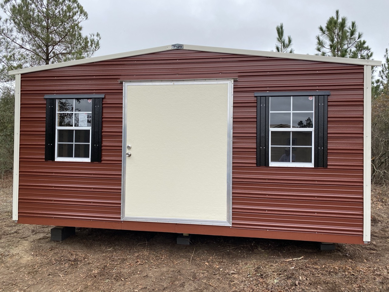 Maroon aluminum shed with black shutters