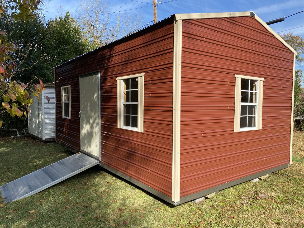 Maroon aluminum shed with ramp and windows