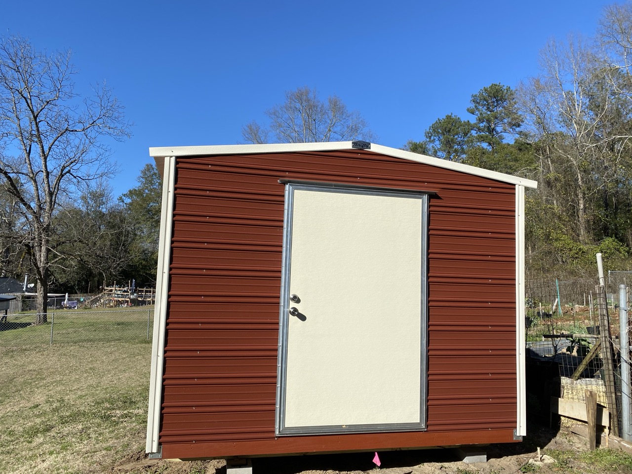 Small maroon aluminum shed