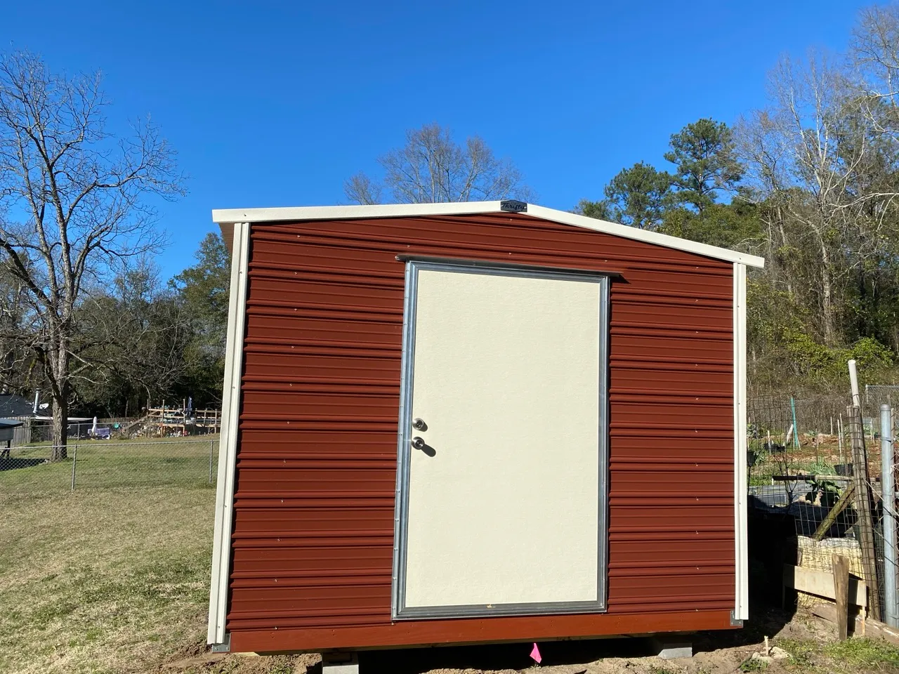 Small maroon aluminum shed