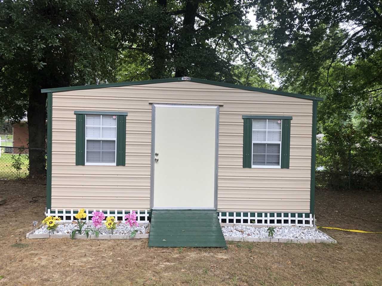 Tan aluminum shed with green trim at customer property