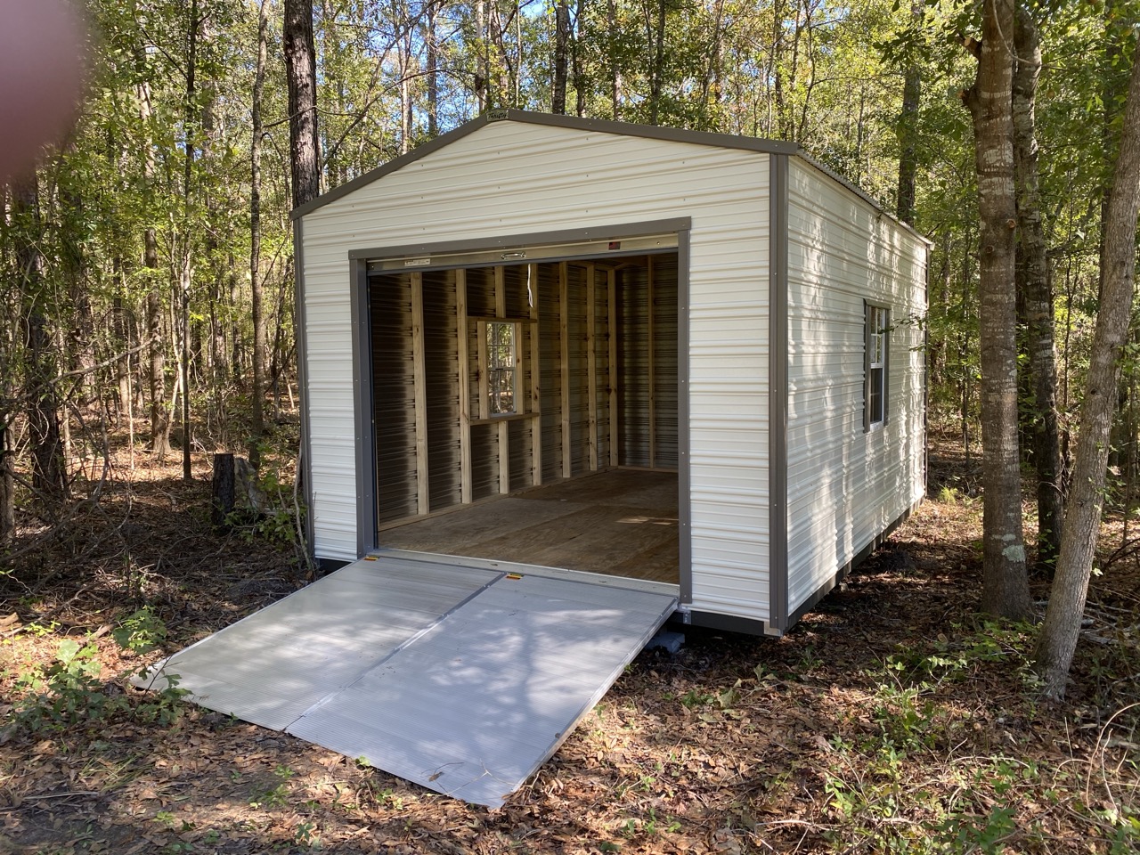 Aluminum shed with roll-up door open showing interior