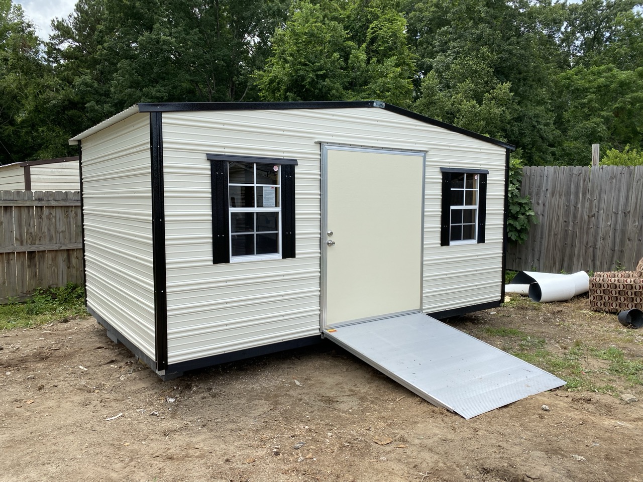White aluminum shed with black shutters