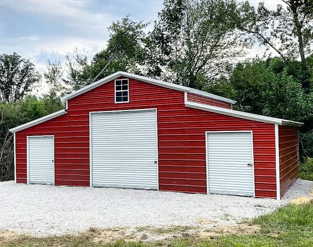 Large red enclosed barn with three roll-up doors