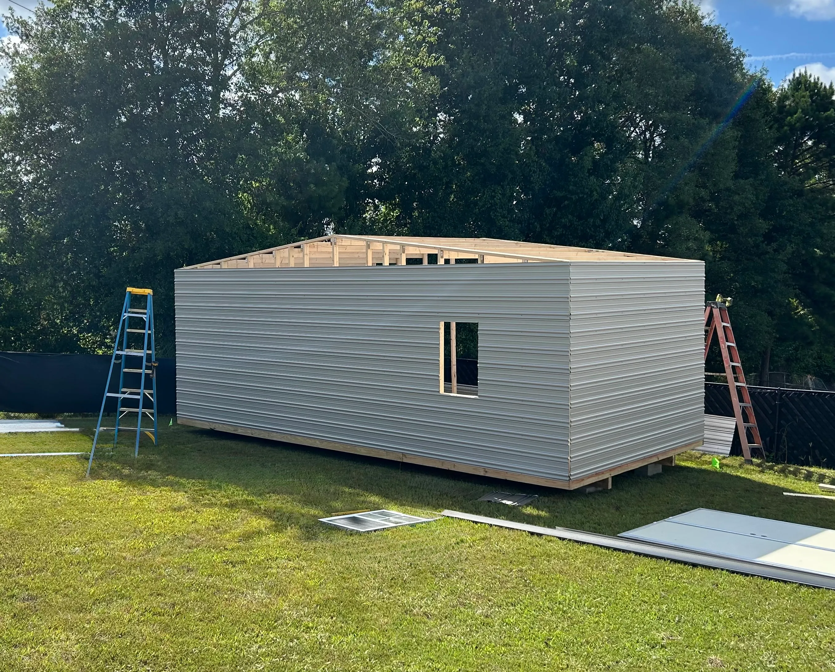 Aluminum siding being applied during on-site build