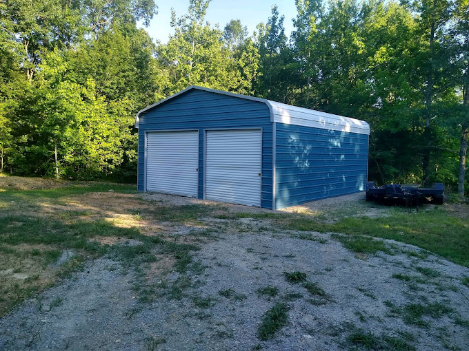 Enclosed metal garage with two roll-up doors